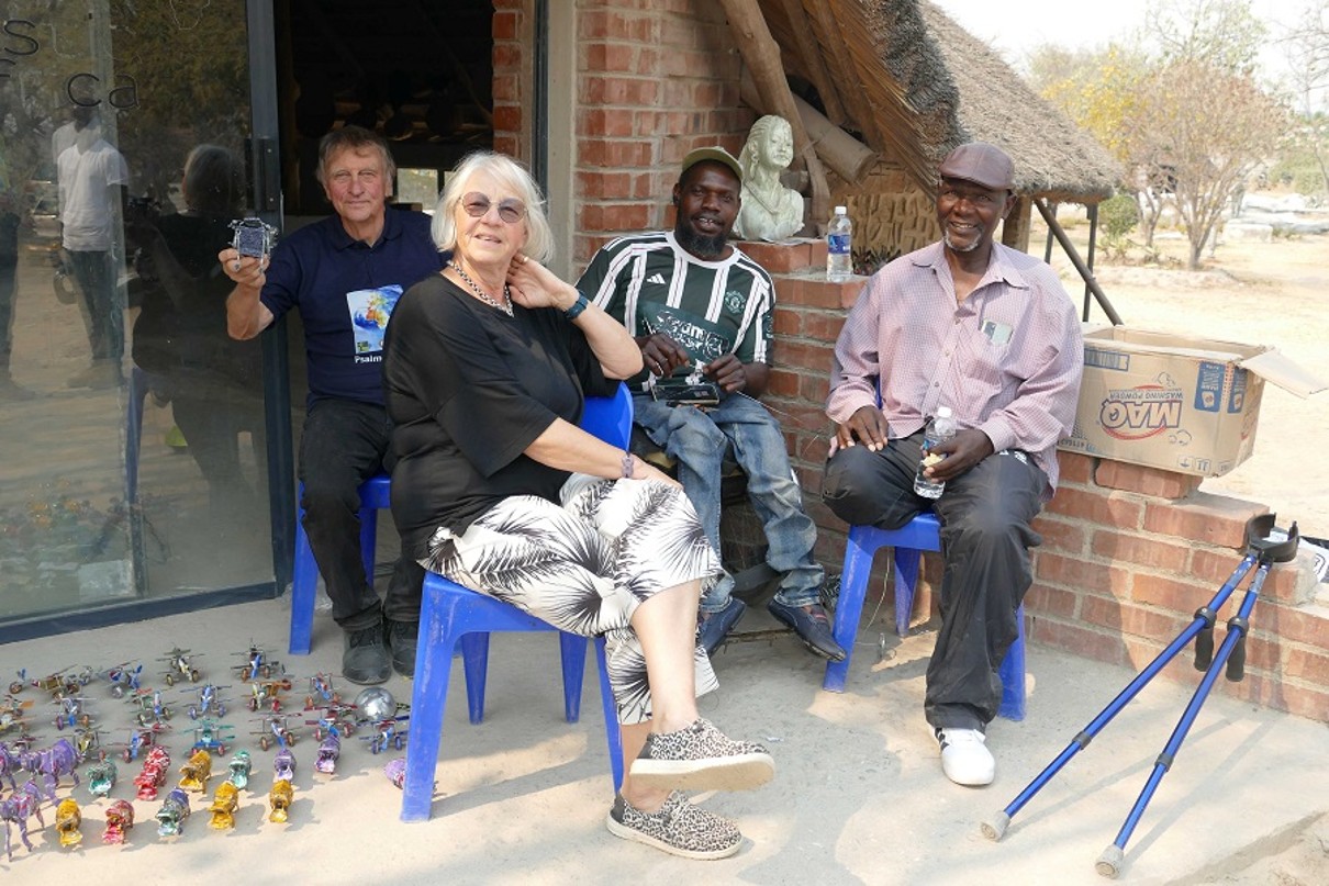 Die Mitglieder der Deutsch-Simbabwischen Gesellschaft sitzend vor einem Haus. 