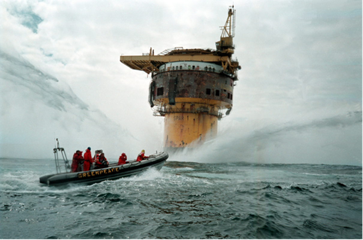  Ein Schlauchboot bei rauer See vor einer Ölplattform. 